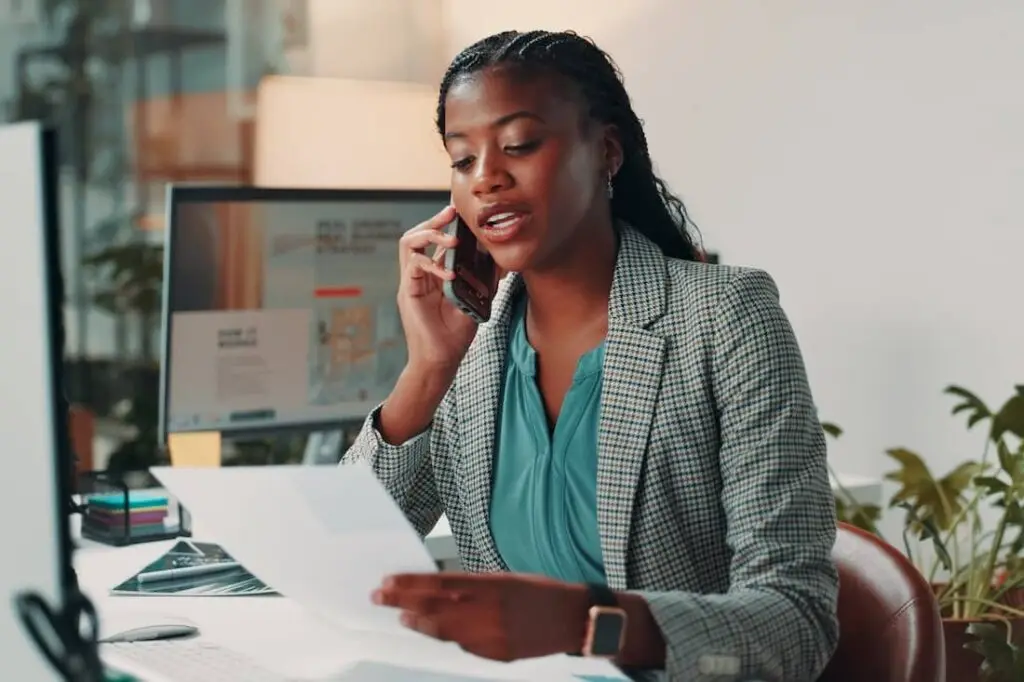 Female business office administrator in office reviewing documents.